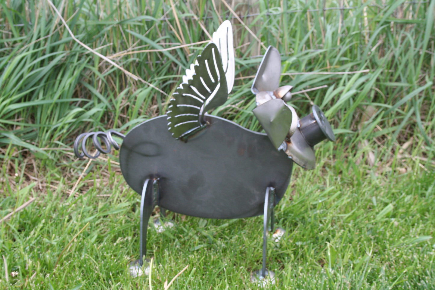 Flying pig metal garden statue in raw steel