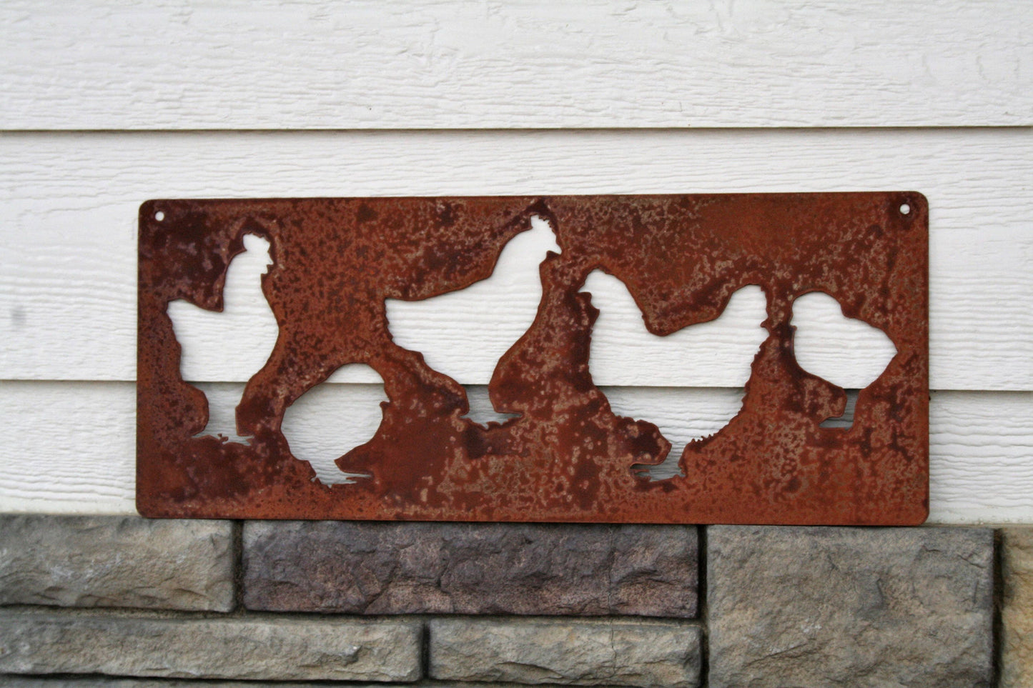 Rusty metal hanging chicken sign with silhouettes of hens and chicks