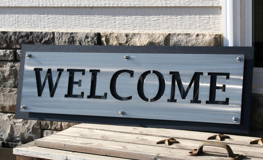 Aluminum over black latered metal welcome sign