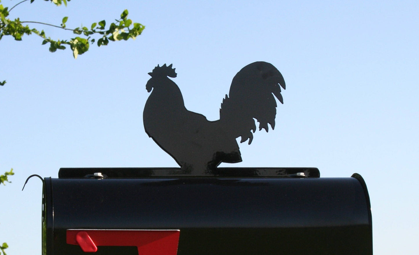 Black rooster mailbox topper installed on a mailbox