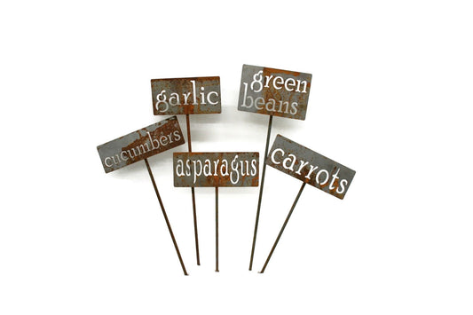 Rusty garden markers for cucumber, radish, asparagus, garlic, green beans, and carrots