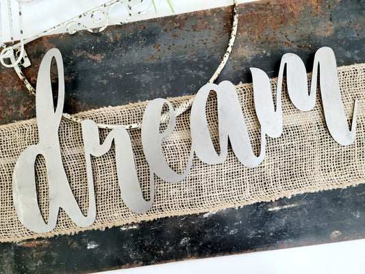dream metal script word sign in raw steel
