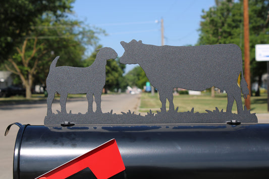Black cow and goat mailbox topper installed on a mailbox.