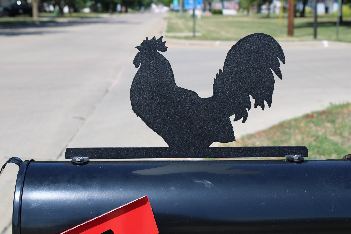 Black rooster mailbox topper installed on a mailbox