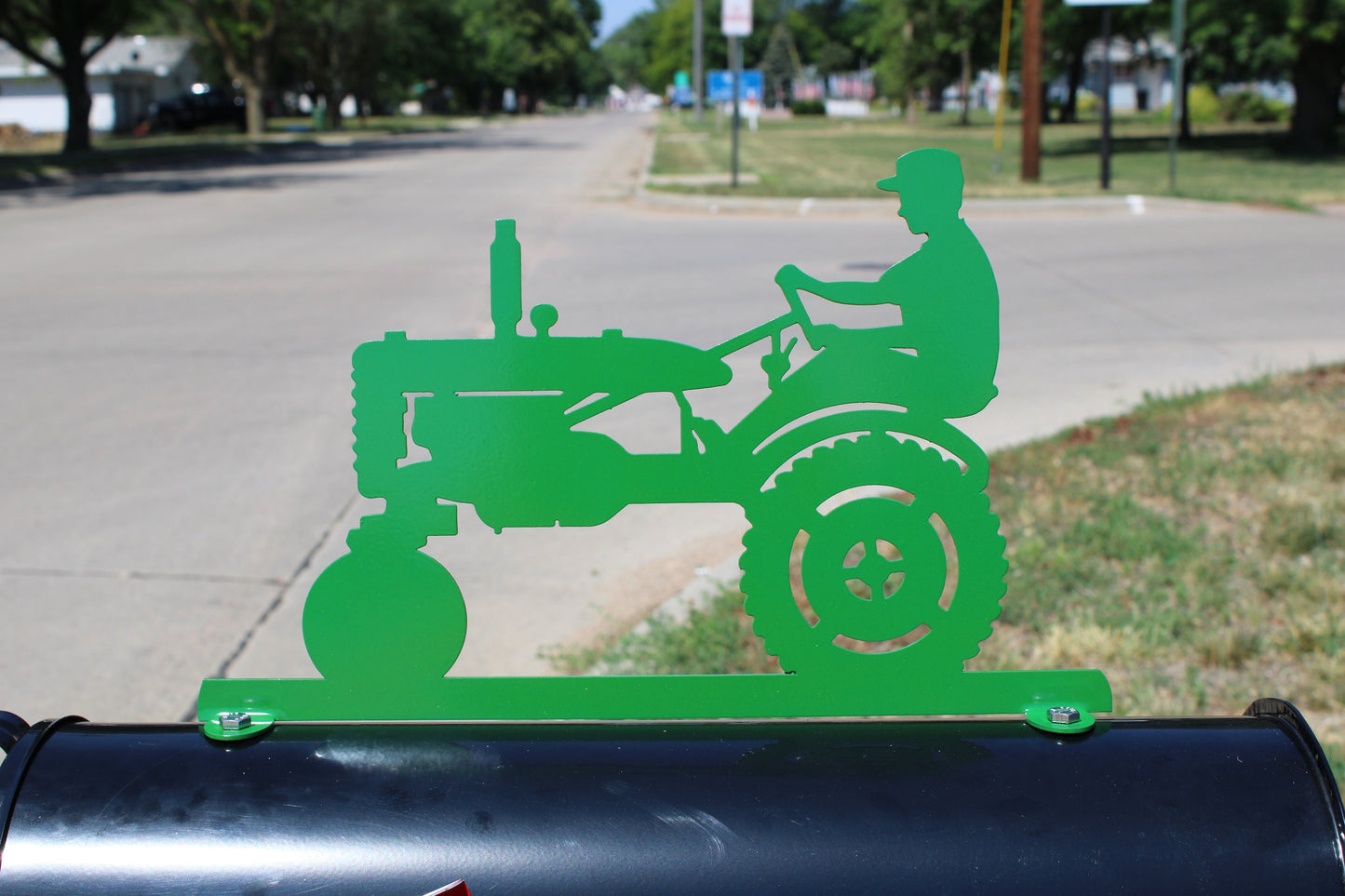Green vintage tractor and driver mailbox topper installed on a mailbox