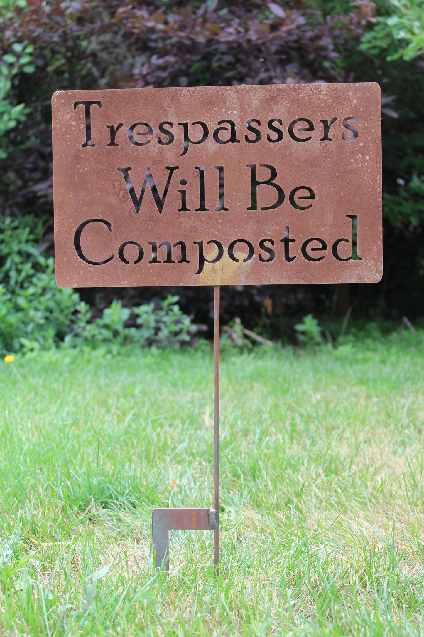 Trespassers will be composted large rusty garden stake sign