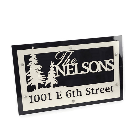 Cabin theme cream over black layered metal name and address sign with evergreen trees