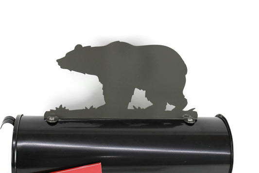 Dark gray metal bear mailbox topper installed on a mailbox.