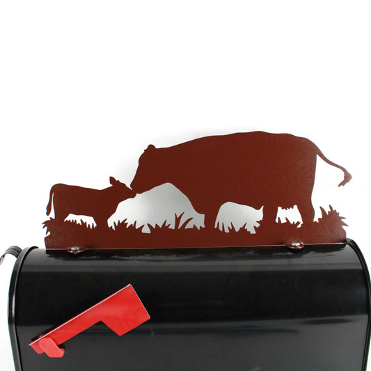 Hammered brown cow and calf touching noses mailbox topper installed on a mailbox.