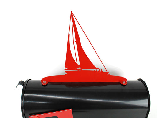 Red sailboat mailbox topper installed on a mailbox