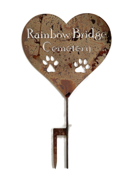 Custom heart-shaped rusty garden stake sign in rust with two paws and Rainbow Bridge Cemetery for text