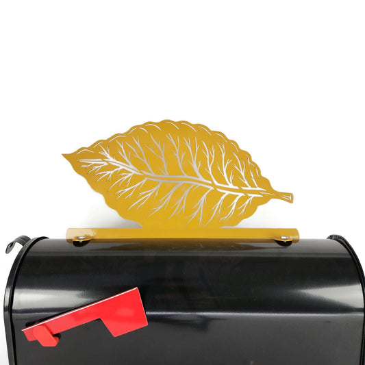 Yellow tobacco leaf mailbox topper installed on a mailbox.