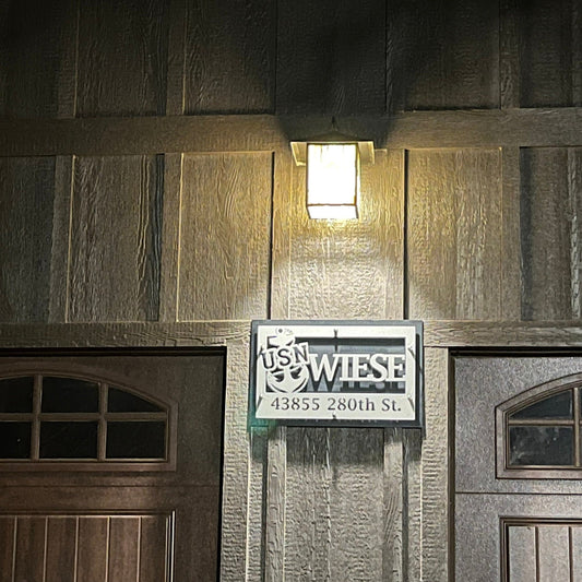 Desert Stone over black layered metal custom Navy family name sign installed on a house