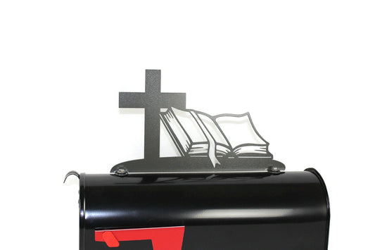 Dark gray cross and bible mailbox topper installed on a mailbox.