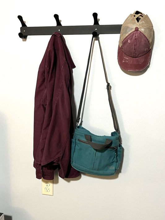 Metal coat and hat rack in matte brown powder coat with coats hanging
