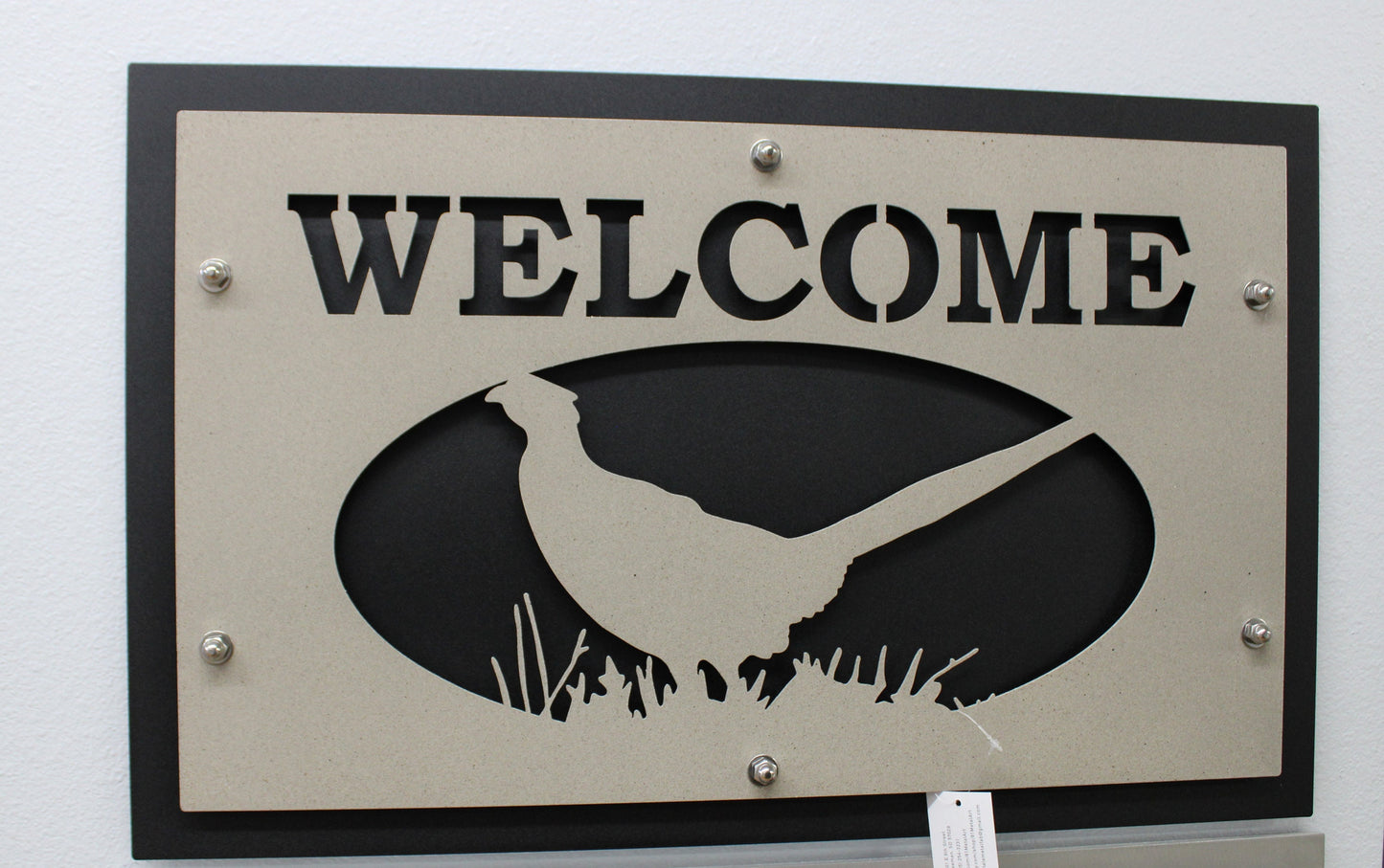 Desert Stone over black layered welcome sign with pheasant