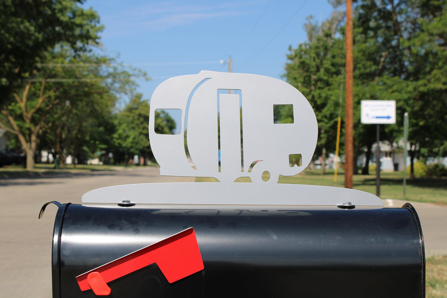 Silver vintage teardrop camper mailbox topper installed on a mailbox