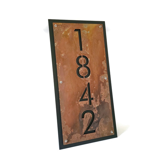 Rust over black layered metal vertical address sign