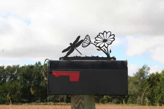 Black dragonfly and daisy mailbox topper installed on a mailbox.