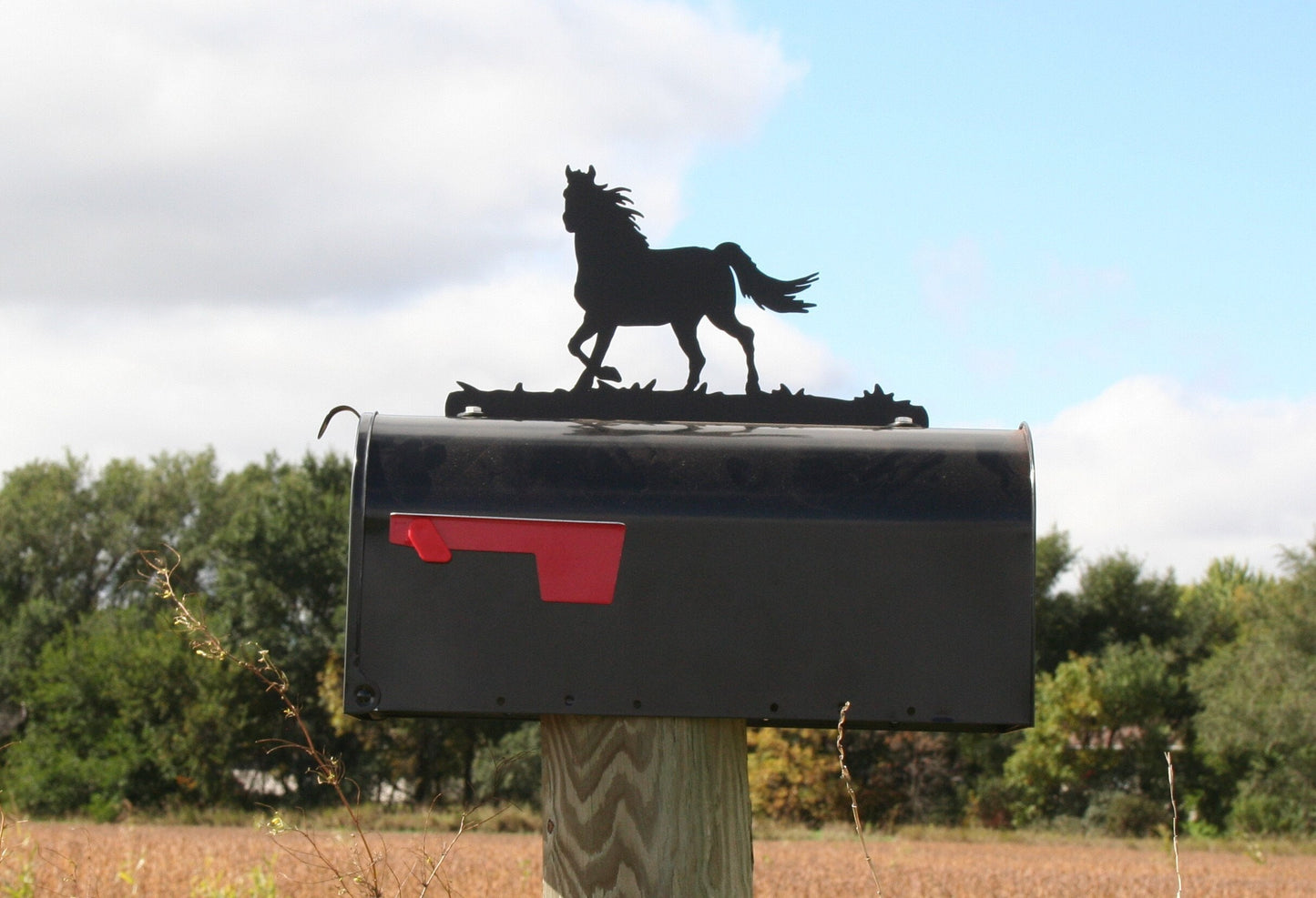 Black running horse mailbox topper installed on a mailbox