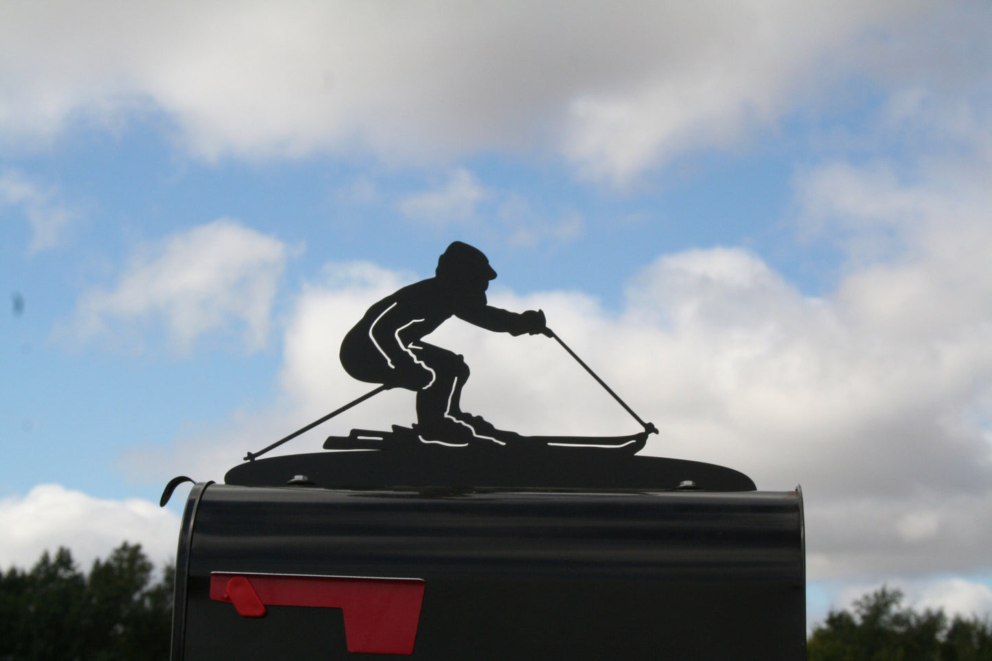 Black downhill skiing mailbox topper installed on a mailbox.