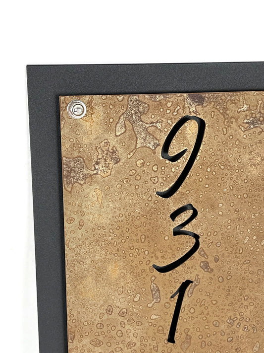 Rust over black vertical layered metal address sign close up