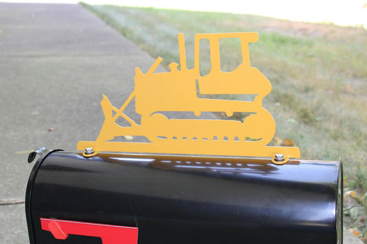 Yellow bulldozer mailbox topper installed on a mailbox.