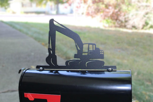 Black excavator mailbox topper installed on a mailbox.