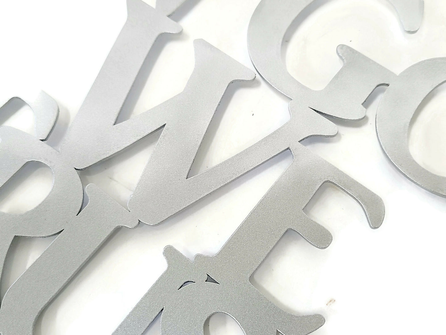 Silver powder coat In God We Trust oval text metal wall sign close up