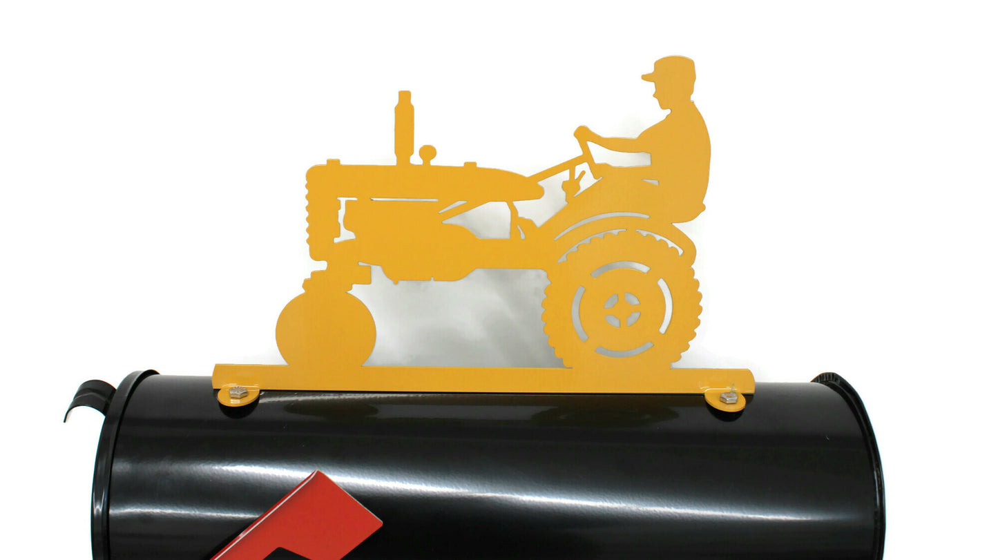 Dark yellow vintage tractor and driver mailbox topper installed on a mailbox