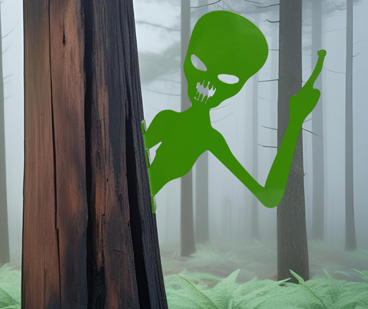Lime green powder coat metal peek a boo alien sign with finger up mounted on a tree