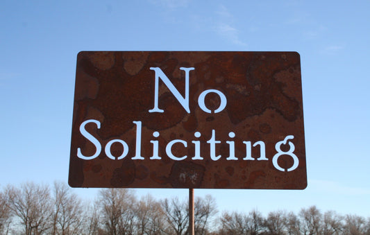 No Soliciting rusty garden stake sign