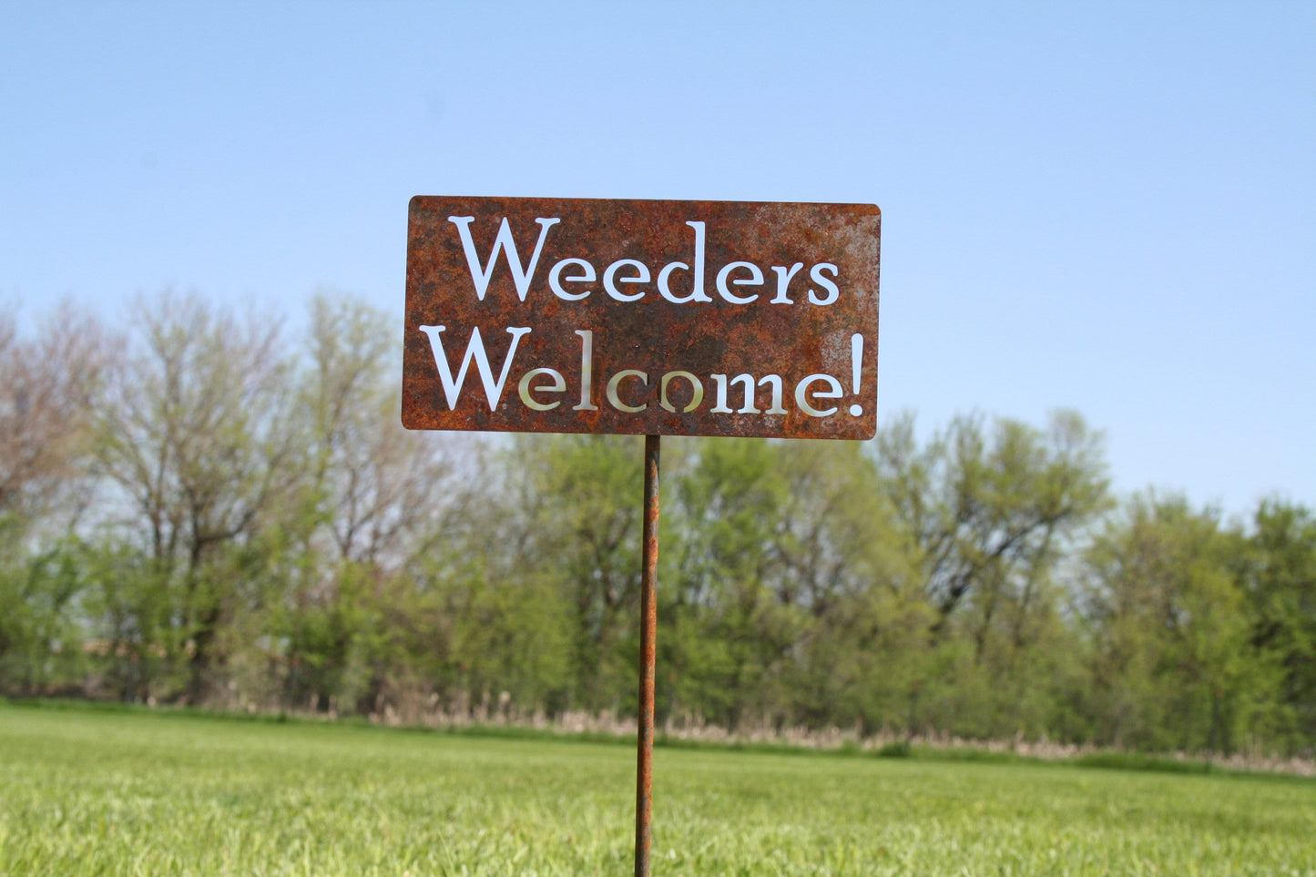 Weeders Welcome rusty garden stake sign