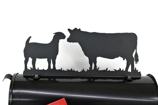 Black cow and goat mailbox topper installed on a mailbox.