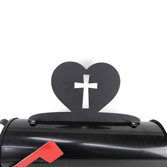 Black cross and heart mailbox topper installed on a mailbox.