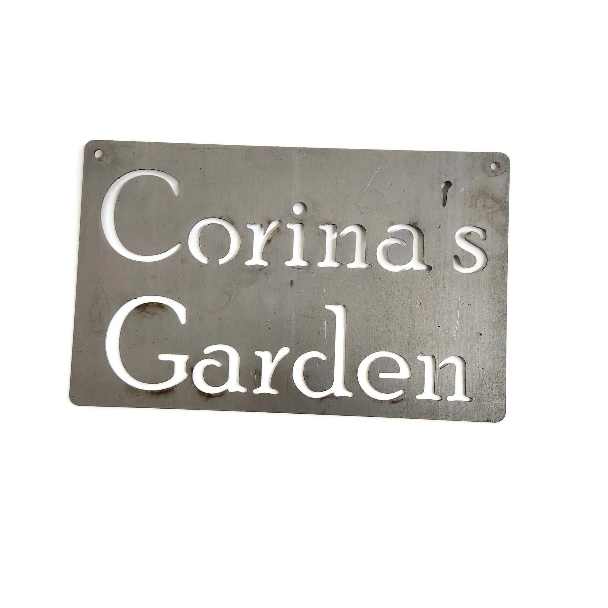 Custom hanging garden sign in raw steel with a wire hanger and Corina's Garden for text