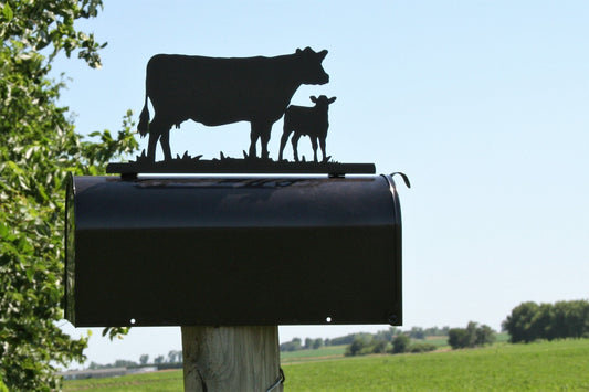 Black cow and calf standing mailbox topper installed on a mailbox.