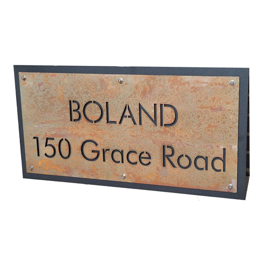 Rust over black layered metal name and address sign