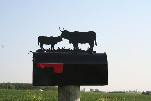 Black highland cow and calf mailbox topper installed on a mailbox