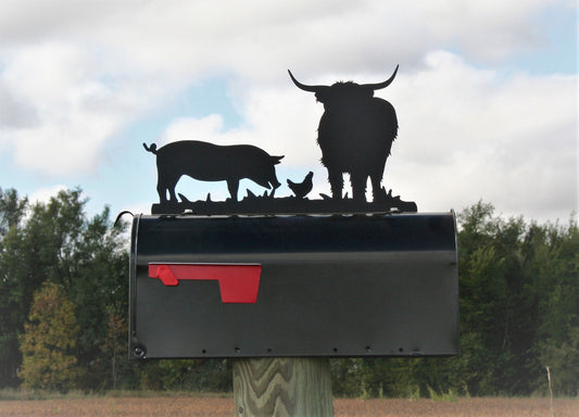 Black highland cow, pig, and chicken mailbox topper installed on a mailbox.