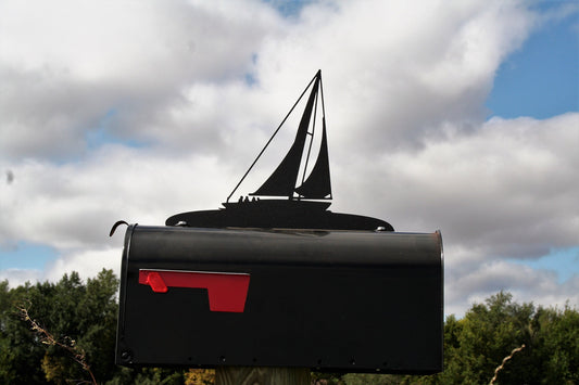 Black sailboat mailbox topper installed on a mailbox