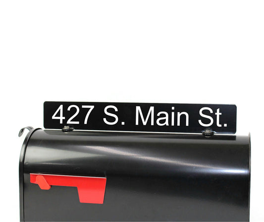 Black custom mailbox topper with custom address installed on a mailbox.