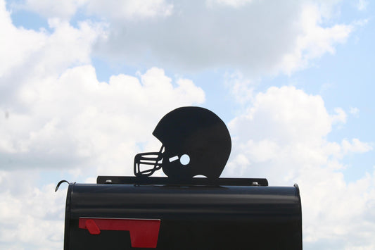 Black football helmet mailbox topper installed on a mailbox
