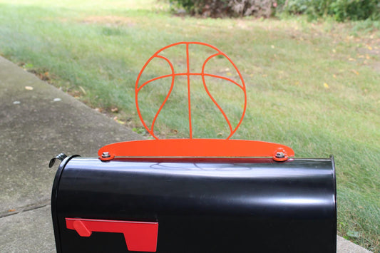 Orange basketball mailbox topper installed on a mailbox.
