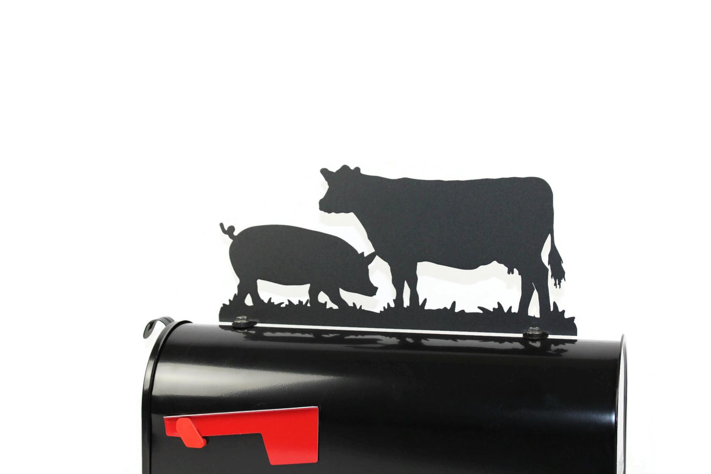 Black cow and pig mailbox topper installed on a mailbox.