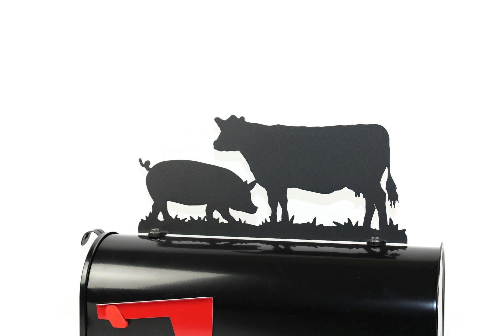 Black cow and pig mailbox topper installed on a mailbox.