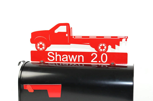Red flatbed truck mailbox topper with name installed on a mailbox.