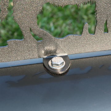 Metal mailbox topper installed onto a mailbox using hardware.